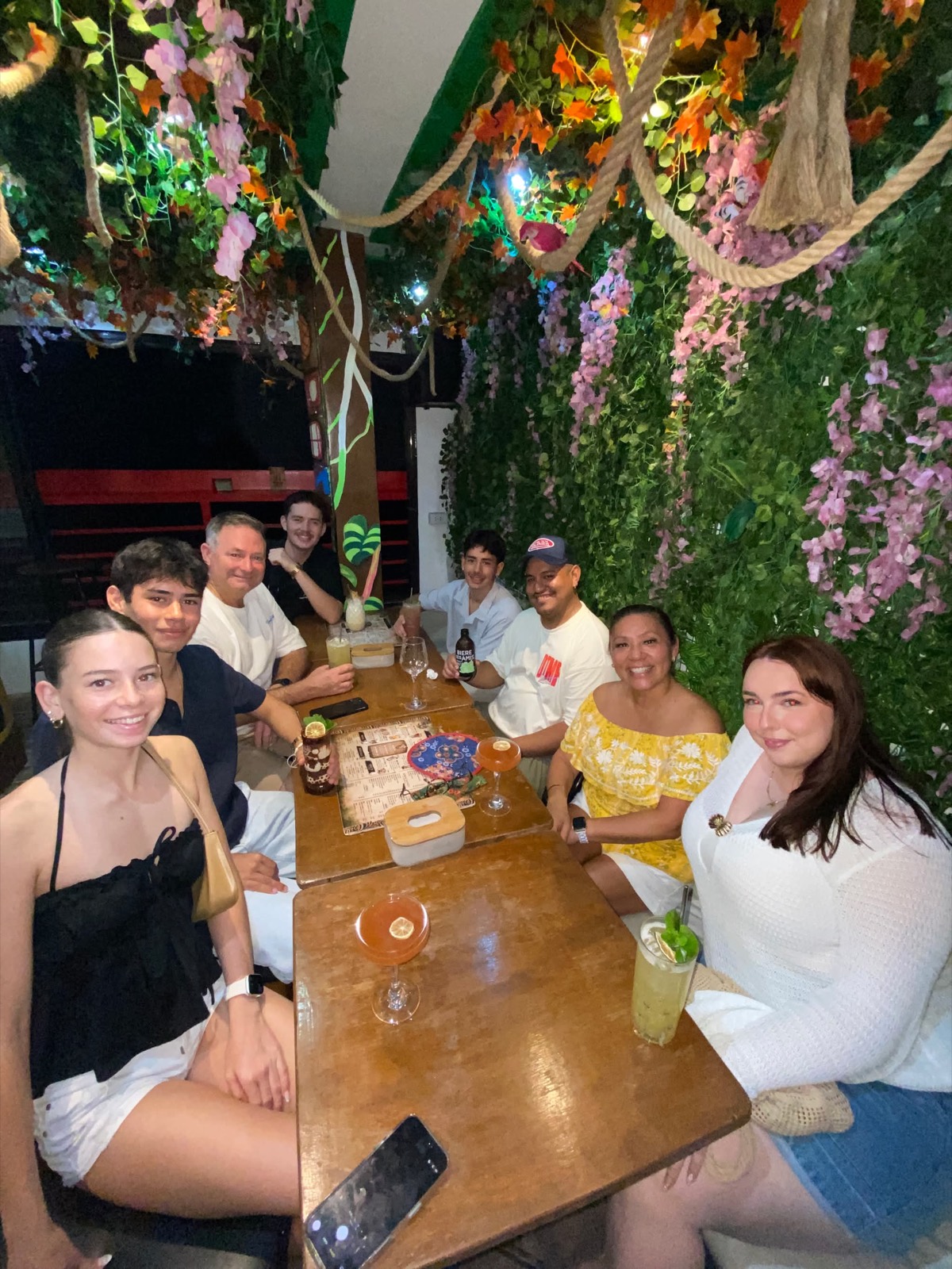 Guests sharing cocktails under the lush floral foliage canopy at Mai Tai Boracay
