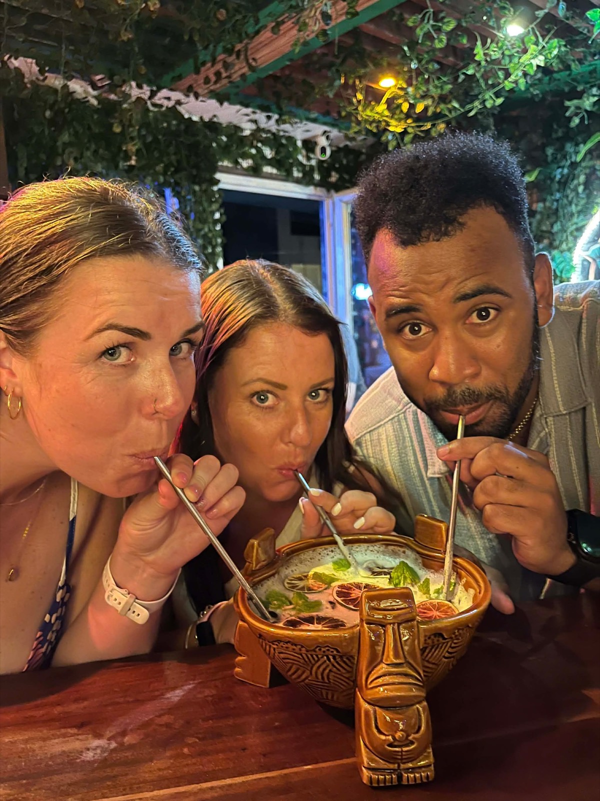 Friends sharing a communal tiki bowl cocktail at Mai Tai Beach Bar Boracay